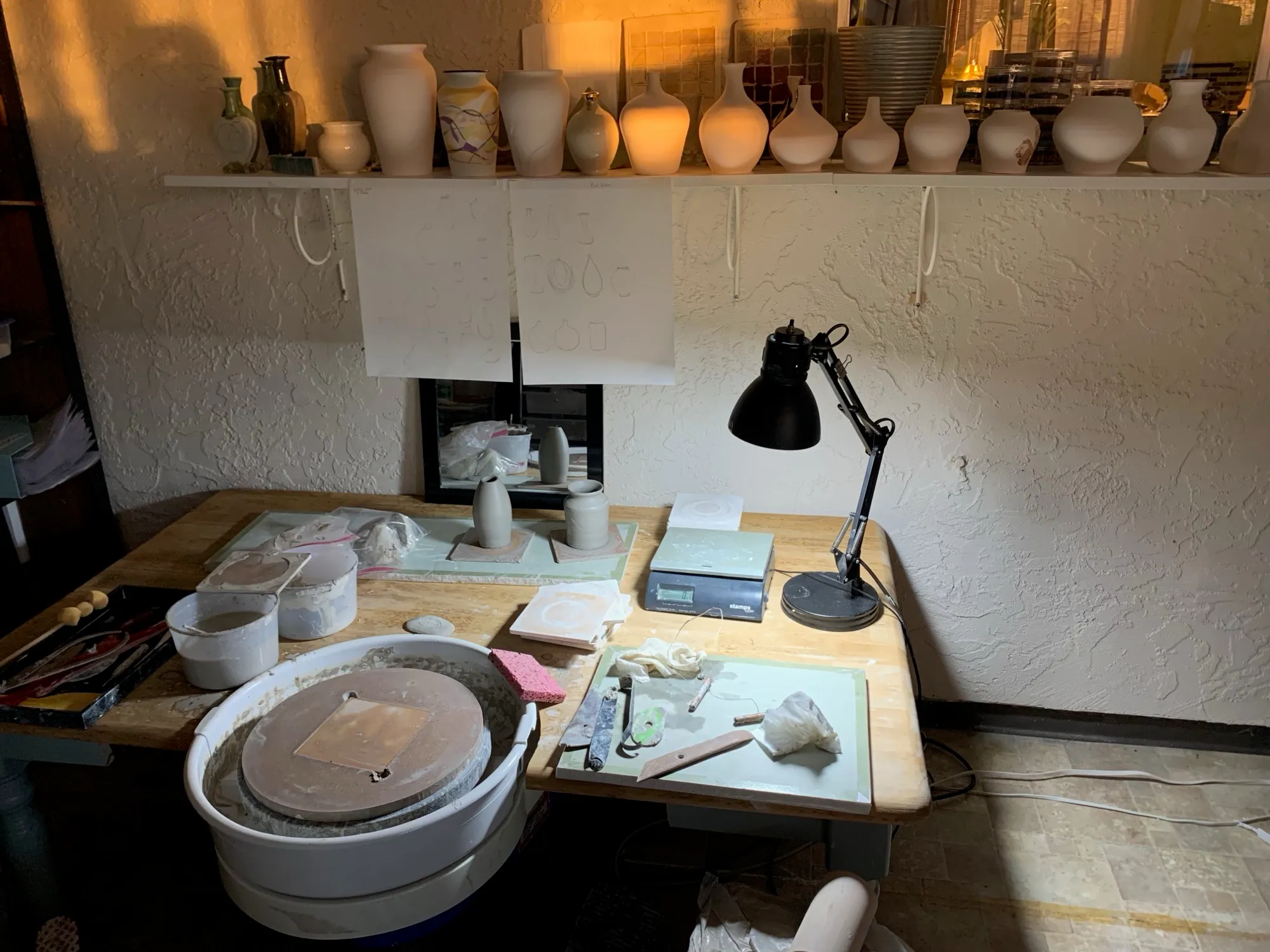 Work table with a banding wheel, lamp, and tools
